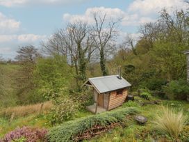 A cabin in a garden area near trees at Tyn Y Fron in Brynherbert near Llanrhystud