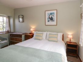 A bedroom with a bed and furniture at Tyn Y Fron in Brynherbert near Llanrhystud