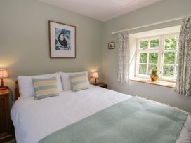 A bedroom with a bed and window at Tyn Y Fron in Brynherbert near Llanrhystud
