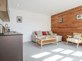 A living room with a sofa and a coffee table at Teach Tra East in Perranporth