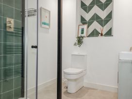 A bathroom with a shower, toilet, and sink at Teach Tra East in Perranporth