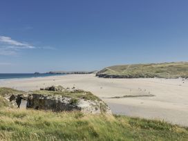 A beach with sand and cliffs at Teach Tra East in Perranporth