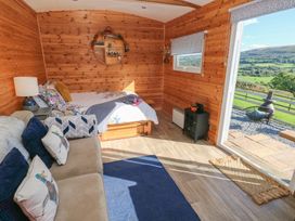 A bedroom with a bed and sofa at Sychnant Farm Retreat in Llanedi near Pontarddulais