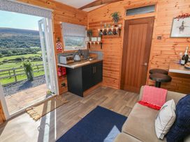 A kitchen with a sofa and appliances at Sychnant Farm Retreat in Llanedi near Pontarddulais