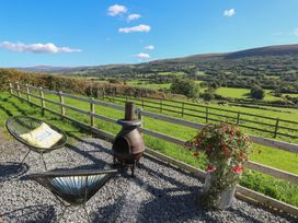 An outdoor seating area with a fire pit and flower pot at Sychnant Farm Retreat Llanedi near Pontarddulais