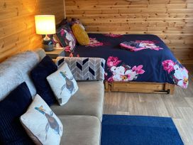 A bedroom with a bed and sofa at Sychnant Farm Retreat Llanedi near Pontarddulais