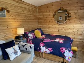 A bedroom with a bed and sofa at Sychnant Farm Retreat in Llanedi near Pontarddulais