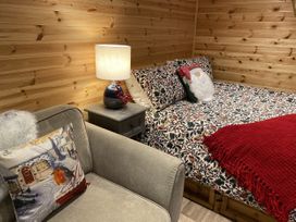 A bedroom with a bed and a chair at Sychnant Farm Retreat in Llanedi near Pontarddulais