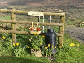 A gate with a sign and flowers at Sychnant Farm Retreat in Llanedi near Pontarddulais