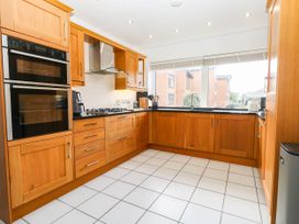 A kitchen with wooden cabinets and appliances at Harbour Heights in Weymouth