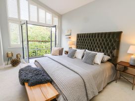 A bedroom with a bed and balcony view at Harbour Heights in Weymouth