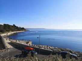 A view of the ocean and shore with people and vehicles at Harbour Heights in Weymouth
