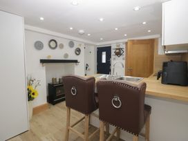 A kitchen with bar stools and a fireplace at Park View Studio in Ambleside