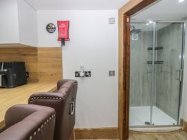 A kitchen with a chair and shower area at Park View Studio in Ambleside