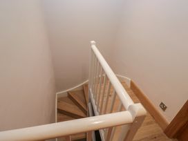 A staircase view with a handrail and wooden floor at Park View in Ambleside