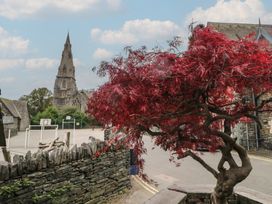 A church and a red tree in a playground area at Park View in Ambleside