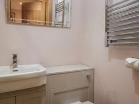 A bathroom with a sink, mirror, and towel rail at Park View in Ambleside