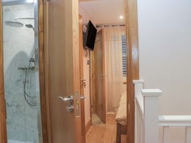 A bathroom with a shower and television at Park View in Ambleside
