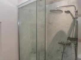 A shower area with a glass door and marble wall at Park View in Ambleside