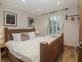 A bedroom with a wooden bed and nightstand at Park View in Ambleside