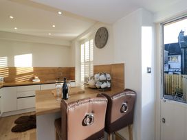 A kitchen with bar stools and wine bottles at Park View in Ambleside