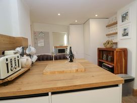 A kitchen with a wooden table and wine bottle at Park View in Ambleside