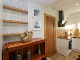 A kitchen with glasses on a shelf and a decorative item on a wooden surface at Park View in Ambleside