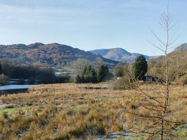 A view of mountains and water with grass and trees at Park View in Ambleside