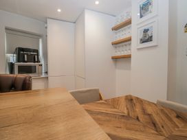 A dining room with a table and shelves holding glassware at Park View in Ambleside
