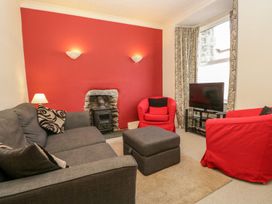 A living room with a sofa and television at The Burrow in Windermere
