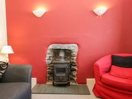A living room with a fireplace and two sofas at The Burrow in Windermere