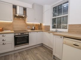 A kitchen with cabinets, stove, sink, and dishwasher at The Burrow in Windermere