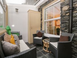 A conservatory with seating and a storage cabinet at The Burrow in Windermere