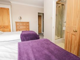 A bedroom with two beds and a shower in the corner at The Burrow in Windermere