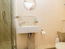 A bathroom with a sink, mirror, and toilet at The Burrow in Windermere