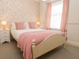A bedroom with a bed and nightstand at The Burrow in Windermere