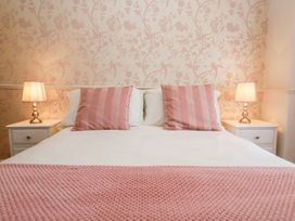 A bedroom with a bed and bedside tables at The Burrow in Windermere