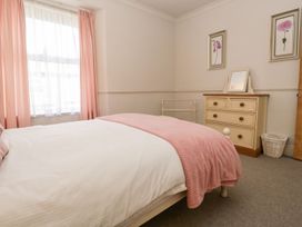 A bedroom with a bed and dresser at The Burrow in Windermere