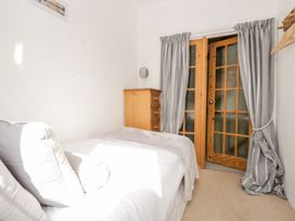 A bedroom with a bed and a wooden dresser at The Burrow in Windermere