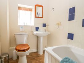 A bathroom with a toilet, sink, and bathtub at The Burrow in Windermere