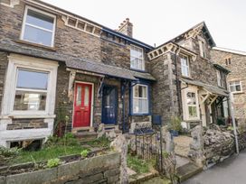 A stone house with red and blue doors and gardens at The Burrow in Windermere