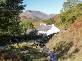 A house near a stream with mountains in the background at The Burrow Windermere