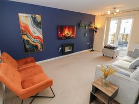 A living room with a fireplace and television at 9 Ffordd Donaldson in Swansea
