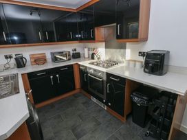 A kitchen with appliances and cabinets at 9 Ffordd Donaldson in Swansea