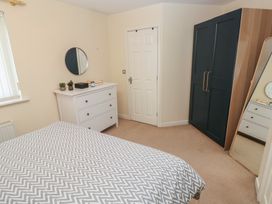 A bedroom with a bed and dresser at 9 Ffordd Donaldson in Swansea
