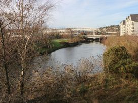 A view of a river with a bridge and buildings at 9 Ffordd Donaldson in Swansea