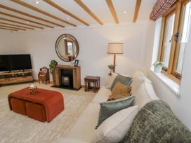 A living room with a television and sofa at Cedar Barn