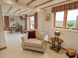 A living room with a sofa and lamp at Cedar Barn