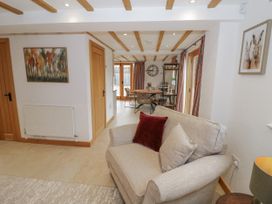 A living room with a sofa and a dining area at Cedar Barn
