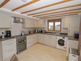 A kitchen with appliances and a window at Cedar Barn